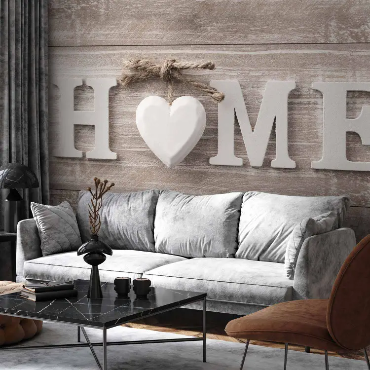 Chaleur domestique - inscription blanche “Home” avec cœur sur fond de planches claires