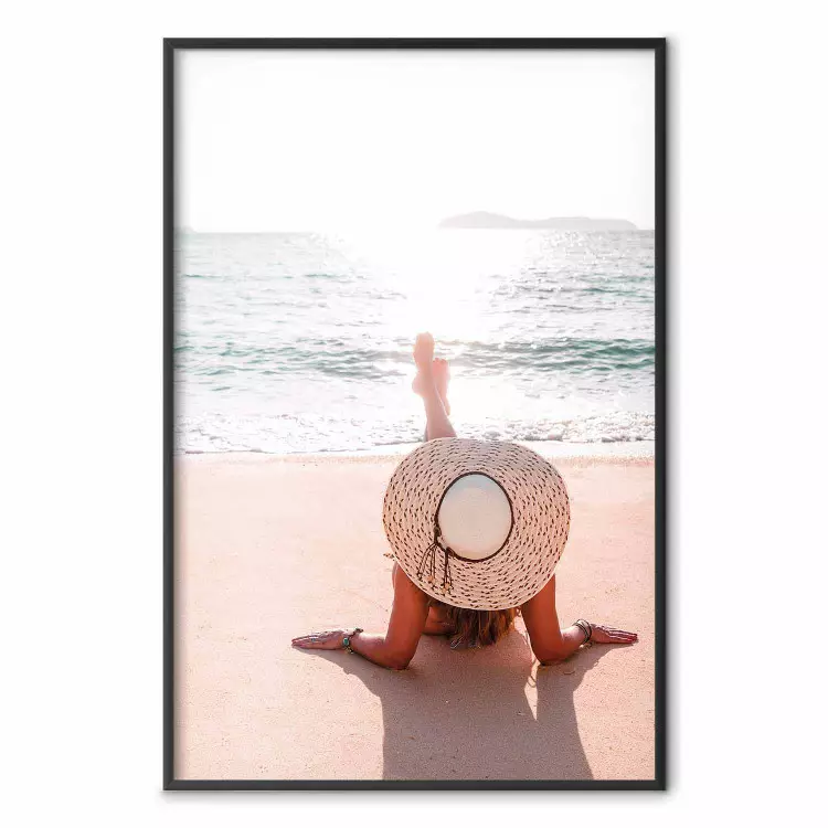 Plage - femme en chapeau allongée sur la plage avec vue sur la mer
